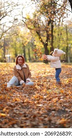 Redhead Mom With White-haired Daughter Are Playing In The Autumn Forest