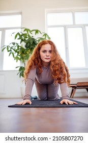 Redhead Overweight Woman Standing With Knees On Fitness Mat, Ready To Train, At Home In Living Room, Caucasian Overweight Lady In Sportive Clothes Want To Lose Weight. Sport, Fitness Concept