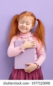 Redhead pretty girl imagine favorite novel characters alive isolated over purple color background. Little child with natural red ginger hair stand with eyes closed smiling with dreaming face - Shutterstock ID 1977123098