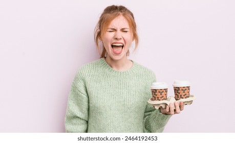 redhead pretty girl shouting aggressively, looking very angry. take away coffee concept - Powered by Shutterstock