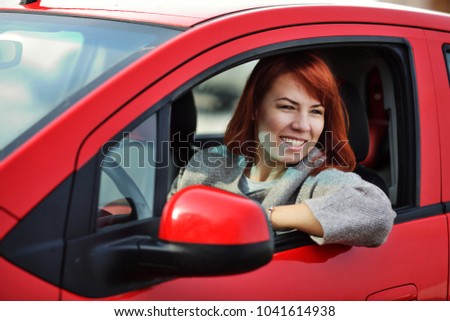 redhead stylish woman driving the red car