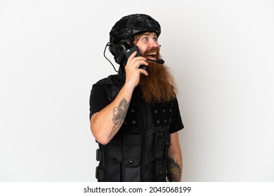 Redhead SWAT Isolated On White Background Keeping A Conversation With The Mobile Phone