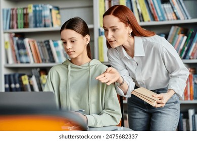 Redhead tutor helping a teenage girl in a library, both engrossed in learning on a laptop. - Powered by Shutterstock