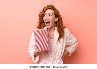 Redhead Woman In Dressing Gown Eating Popcorns