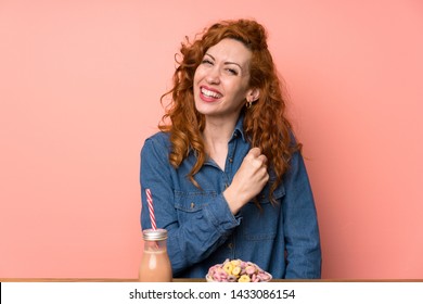 Redhead woman having breakfast cereals and fruit celebrating a victory - Shutterstock ID 1433086154
