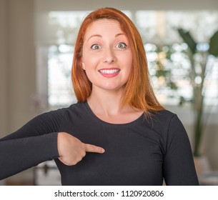 Redhead woman at home with surprise face pointing finger to himself - Shutterstock ID 1120920806