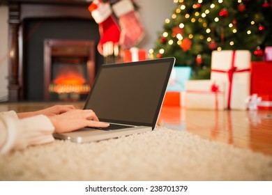 Redhead Woman Lying On Floor Using Laptop At Christmas At Home In The Living Room