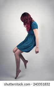Redhead woman in a teal dress floating