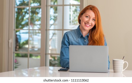 Redhead Woman Using Computer Laptop At Home With A Happy Face Standing And Smiling With A Confident Smile Showing Teeth