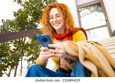 Redhead woman using her phone to communicate with her friends
