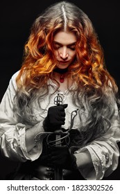 A redhead woman with a war sword (rapier) prays while holding a sword . The heroine of a historical adventure novel.
