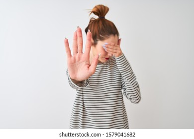 Redhead woman wearing navy striped t-shirt standing over isolated white background covering eyes with hands and doing stop gesture with sad and fear expression. Embarrassed and negative concept.
