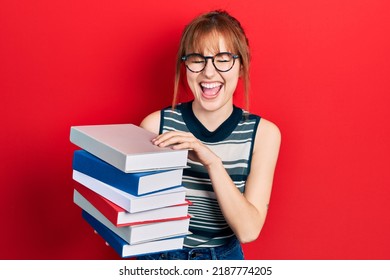 Redhead Young Woman Holding A Pile Of Books Smiling And Laughing Hard Out Loud Because Funny  Joke. 