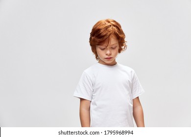 redheaded teen looking down white t-shirt cropped view studio  - Powered by Shutterstock