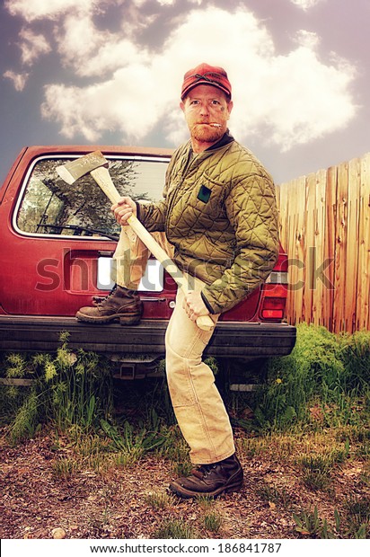 a redneck man with an ax in his hands done with a\
warm filter
