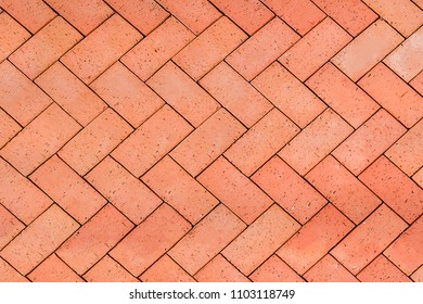 Red-Orange bricks tiled floor with zigzag pattern texture background.