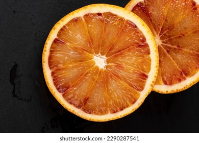the red-orange flesh of an orange sliced in close-up, juicy multicolored flesh of an orange cut into pieces