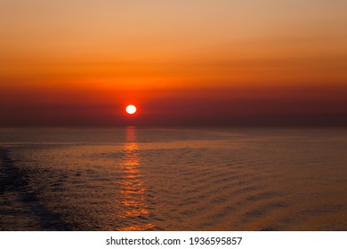 Red-orange sunset on the sea. Red sun on the horizon at sunset on the high seas.
