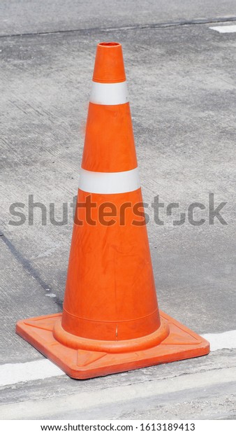 A\
red-orange traffic cone was placed on the\
road