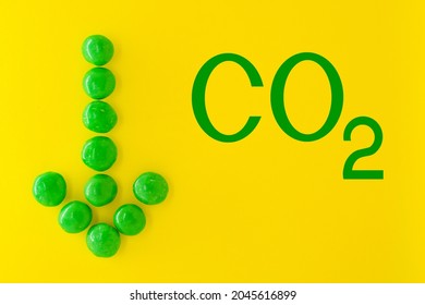 Reduce Carbon Dioxide Emissions And Limit Global Warming And Climate Change Concept. CO2 Sign And Green Arrow Pointing Down