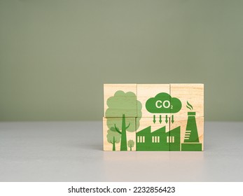 Reduce CO2 emission concept. Net zero greenhouse gas emissions target. Sustainable development and business based on renewable energy. Wooden cubes with eco-friendly icons on a green background - Shutterstock ID 2232856423