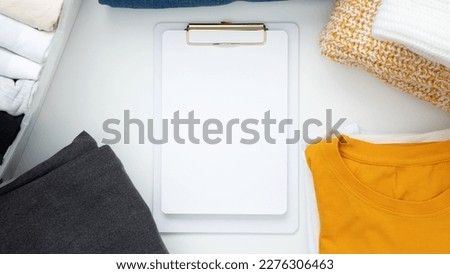 Reduce and reuse concept. Preparing clothes for swap. Waste problem in fashion industry. Vertical storage of clothing, tidying up, garments declutter and sorting. Top view.  Copy spase
