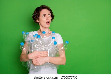 Reduce Reuse Recycle. Photo of beautiful lady hold many plastic bottles angry face carry trash recycling service look side empty space displeased isolated green color background