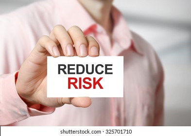 Reduce Risk Text On The Card In Hand Man.