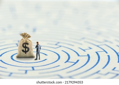 Reducing or overcome financial barrier, financial concept : US dollar bag on a maze puzzle with a businessman considers how to overcome financial difficulties. CFO wishes to avoid a financial crisis. - Shutterstock ID 2179294353