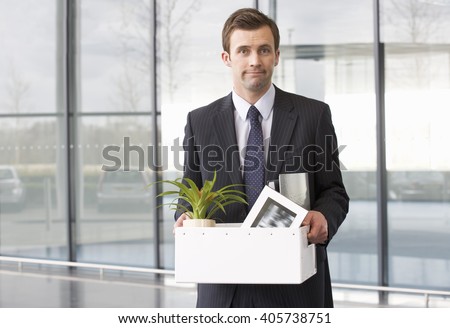 A redundant businessman taking his belongings home in a box