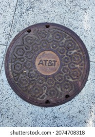 Redwood City, CA, USA - November 2021: AT+T manhole cover on the street in the San Francisco Bay area.