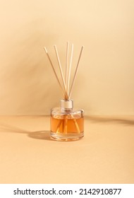 Reed Diffuser Bottle On A Beige Background. Incense Sticks For The Home With A Floral Scent. The Concept Of Eco-friendly Fragrance For The Home