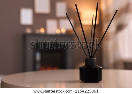 Reed diffuser on white table indoors. Space for text