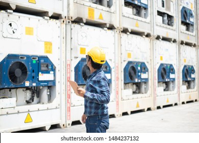 A Reefer Container Technician Is Looking And Take Care Of Frozen Or Chill Cargo With Handling Tablet While Working In The Storage Yard.