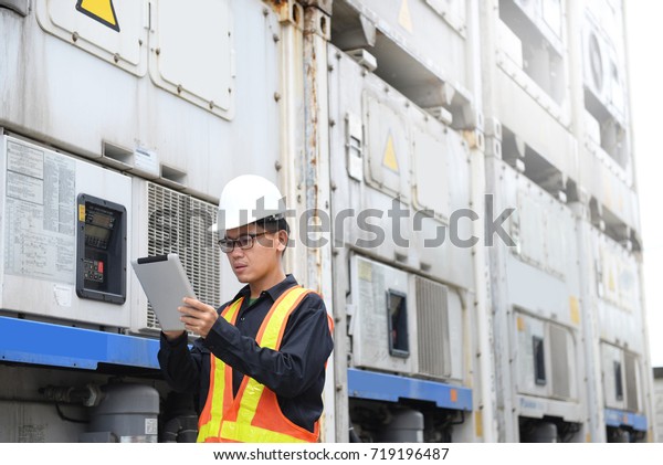  Reefer\
container technician is using tablet for monitoring temperature of\
frozen & chill shipments.