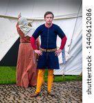 A re-enactment medieval squire poses for the cameras will his wife complains about the leaking tent, The encampment 