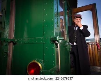 Reenactment scene with authentic 1927 1st class train carriage and a retro train conductor at departure - Powered by Shutterstock