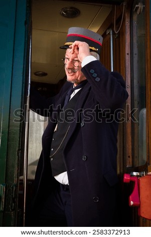 Reenactment scene with authentic 1927 1st class train carriage and a retro train conductor at departure