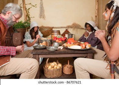 Reenactment Scene Of The First Thanksgiving Dinner In Plymouth In 1621 With A Pilgrim Family And A Wampanoag Indian