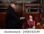 Reenactment scene of a vintage steam train conductor in a 1927 authentic first class train interior