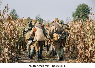 Reenactors Men Dressed As Russian Soviet Red Army Infantry Soldiers Of World War II Marching In Field With Weapon Machine-gun At Historical Reenactment