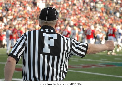 referee giving hand signal at a football game