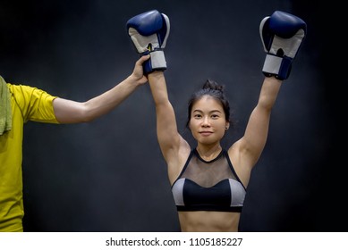 Referee lifting young female boxer hand, winner of the match. Boxing training concept - Powered by Shutterstock