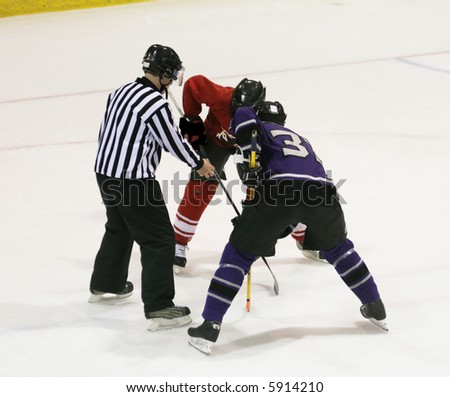 Referee prepares to drop the puck for a faceoff