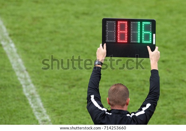 審判はサッカーの試合中に選手の交代を知らせる番号表示を示す の写真素材 今すぐ編集
