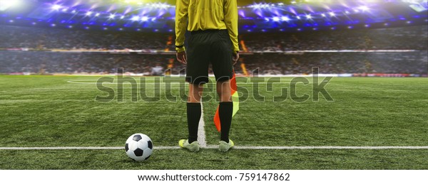 The referee soccer game stands on the\
field before the game, ready to blow the\
whistle