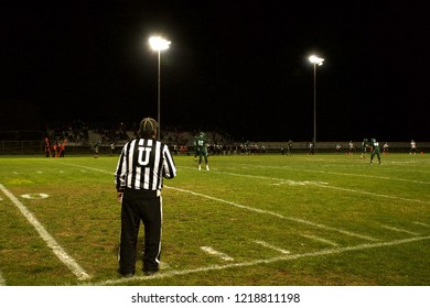 Referee Working At A High School Football Game Under The Lights.