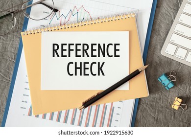 REFERENCE CHECK Is Written In A Document On The Office Desk With Office Accessories.