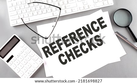 REFERENCE CHECKS text on a paper with keyboard, calculator on grey background