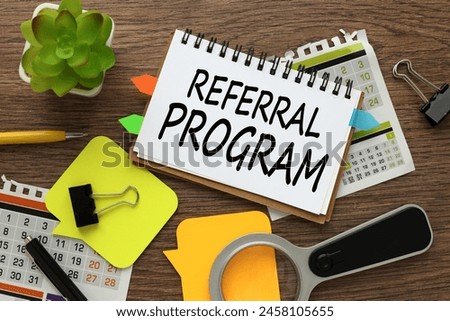 REFERRAL PROGRAM . Business concept. notepad on the calendar. magnifying glass, notepad. potted plant
